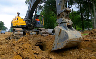 Volvo crawler excavator trenching for laying pipe on a jobsite.
