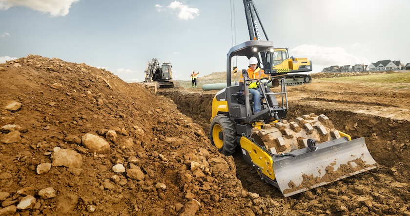 Volvo soil compactor with a padfoot bolt-on shell kit compacting in a trench.