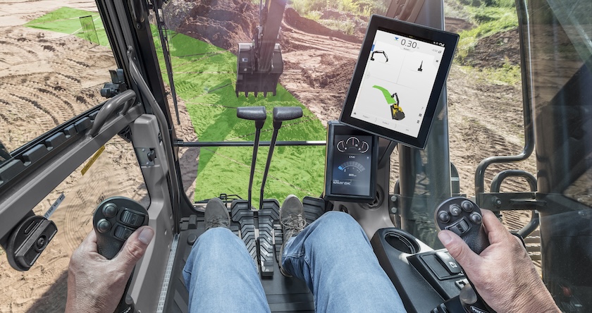 A view of a jobsite from an excavator operator’s perspective. The Dig Assist in-cab display is shown, including virtual “indicators” on the ground of where the operator should be digging.