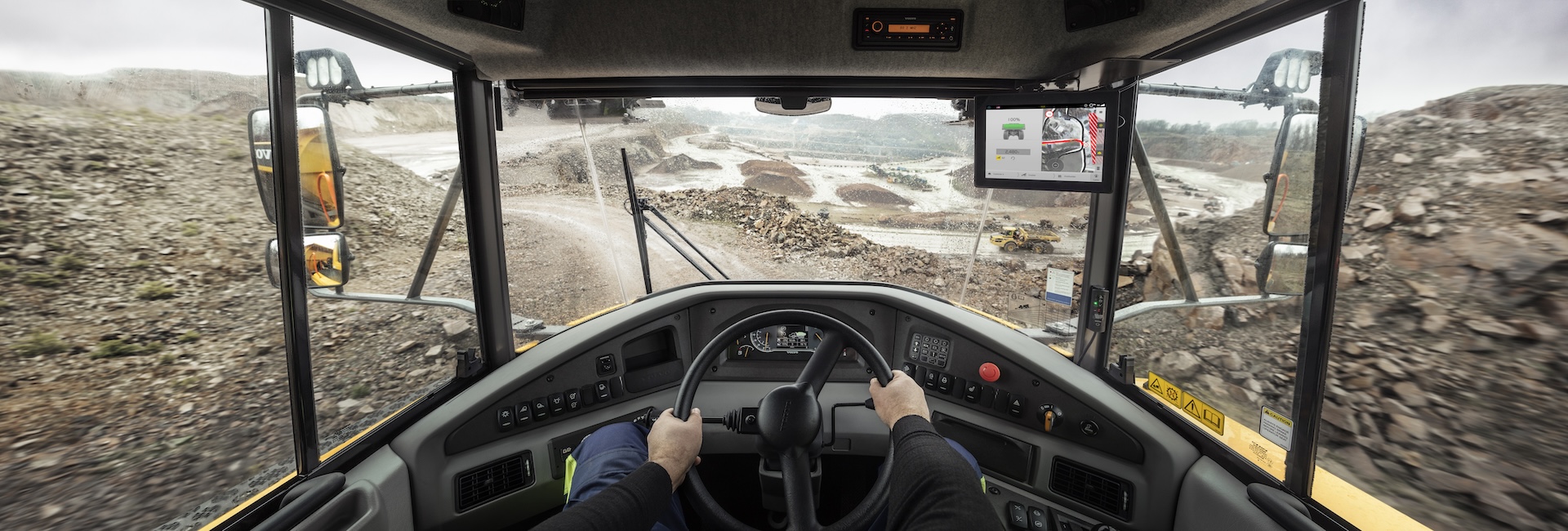 A view of a quarry from a Volvo articulated hauler operator’s perspective. The Haul Assist in-cab display can be seen on the right side of the cab.