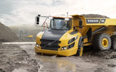 A Volvo A45G articulated hauler driving through deep, wet mud.